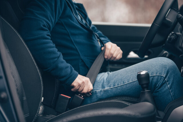 passenger senior man fastening seat belt in the car, transport and safety concept